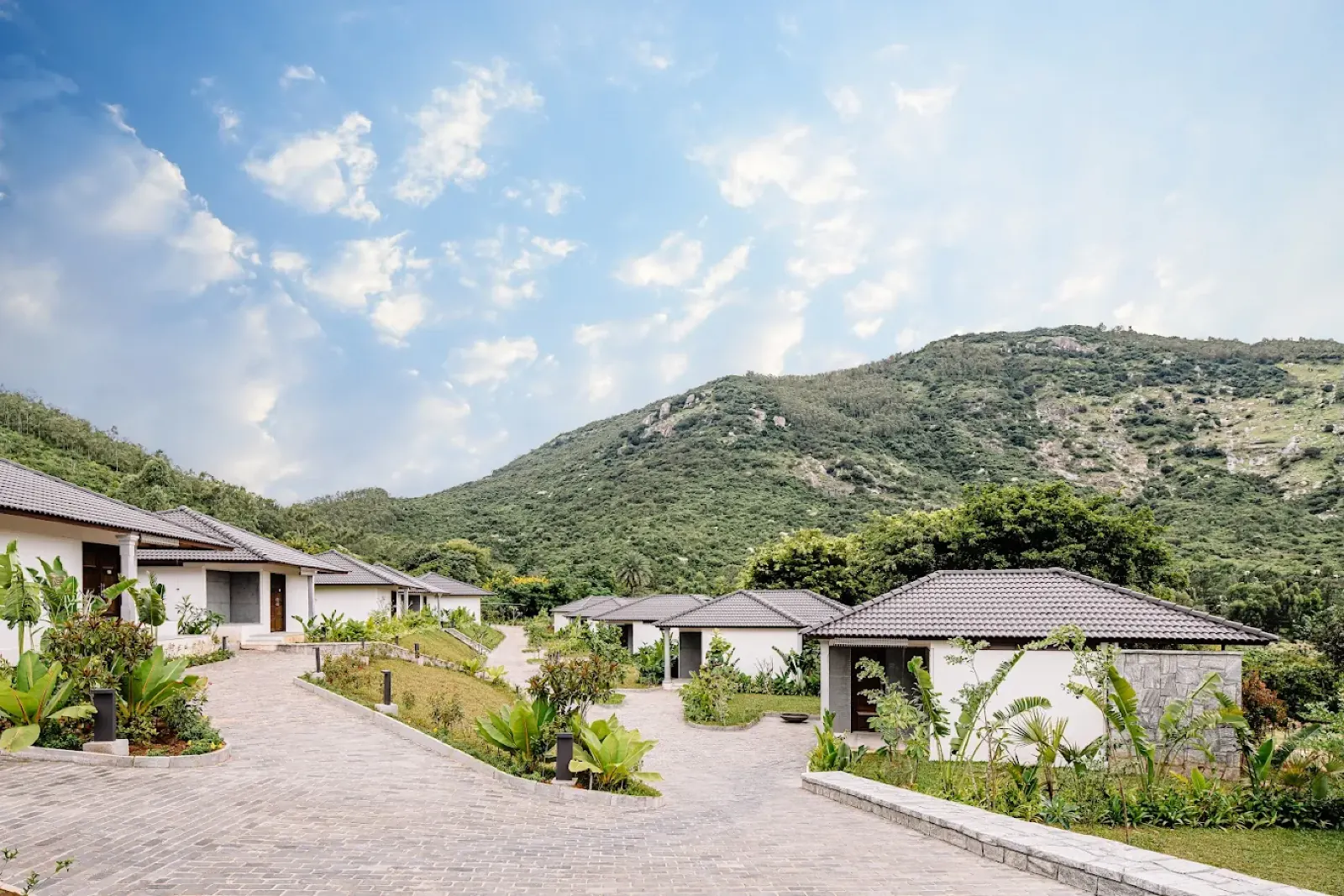 Villas with tiled roofs set against a green hillside