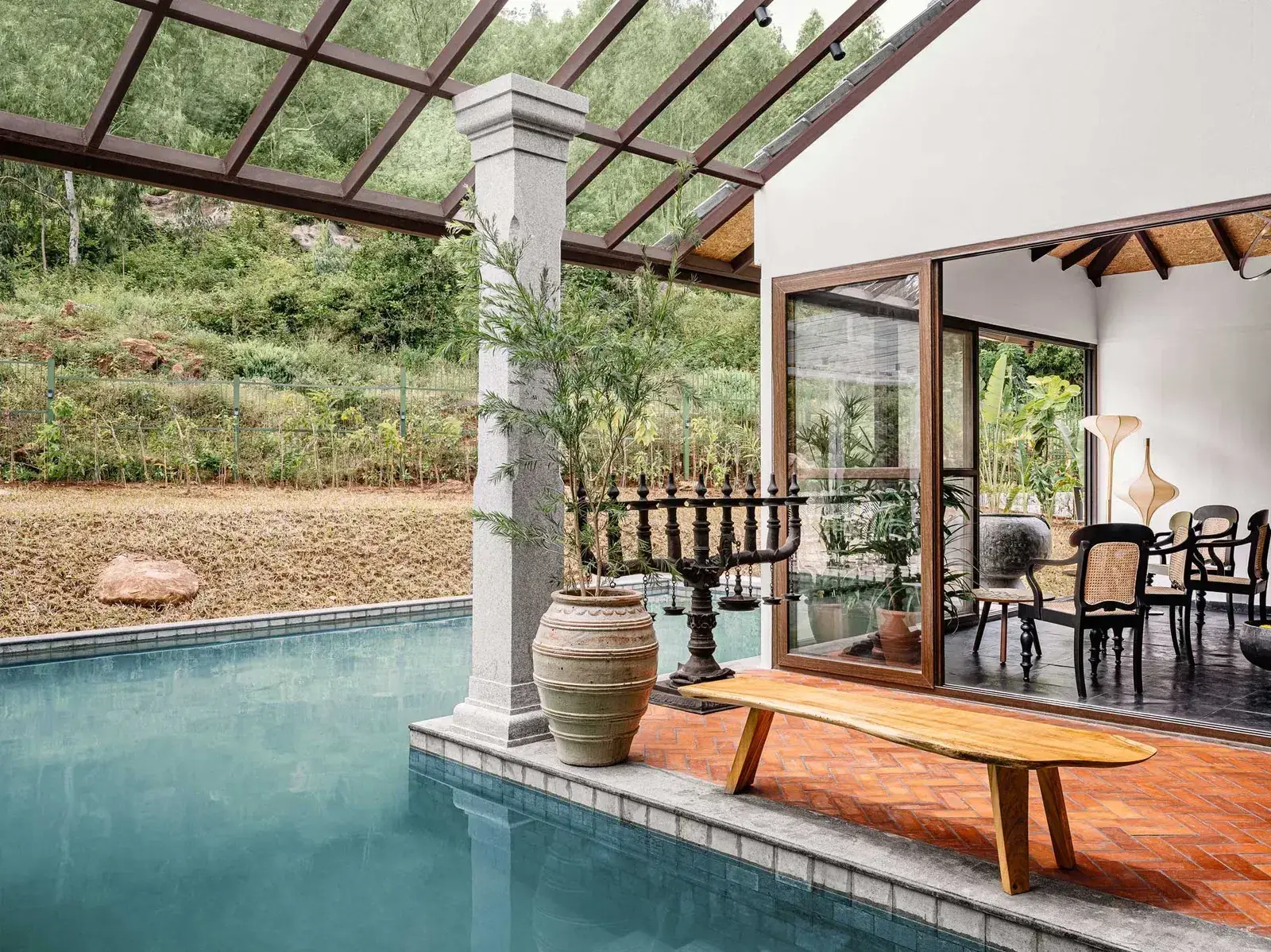 A pool and covered veranda looking out to the hillside