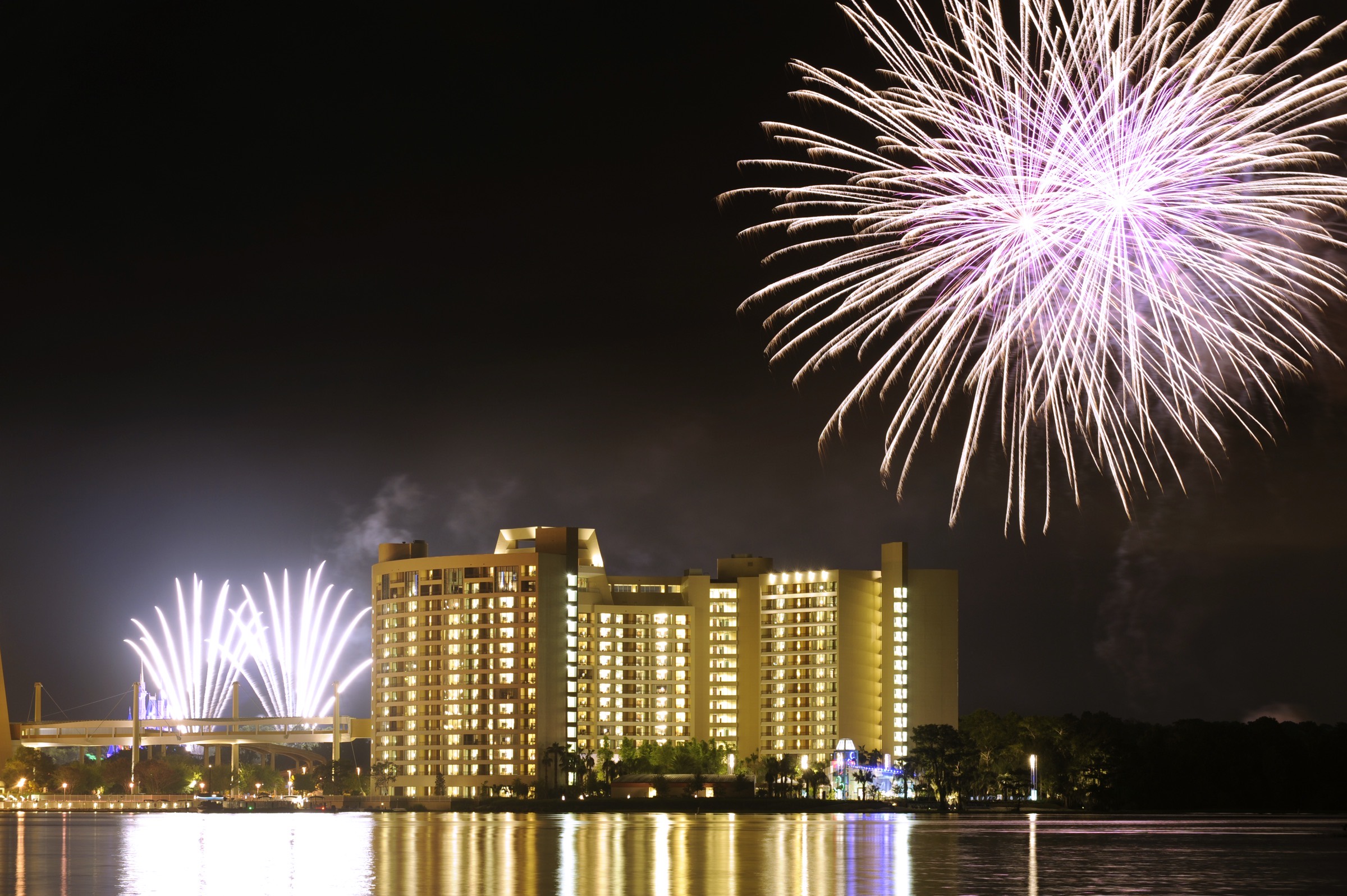 Fireworks bursting above Bay Lake Tower reflected in the water