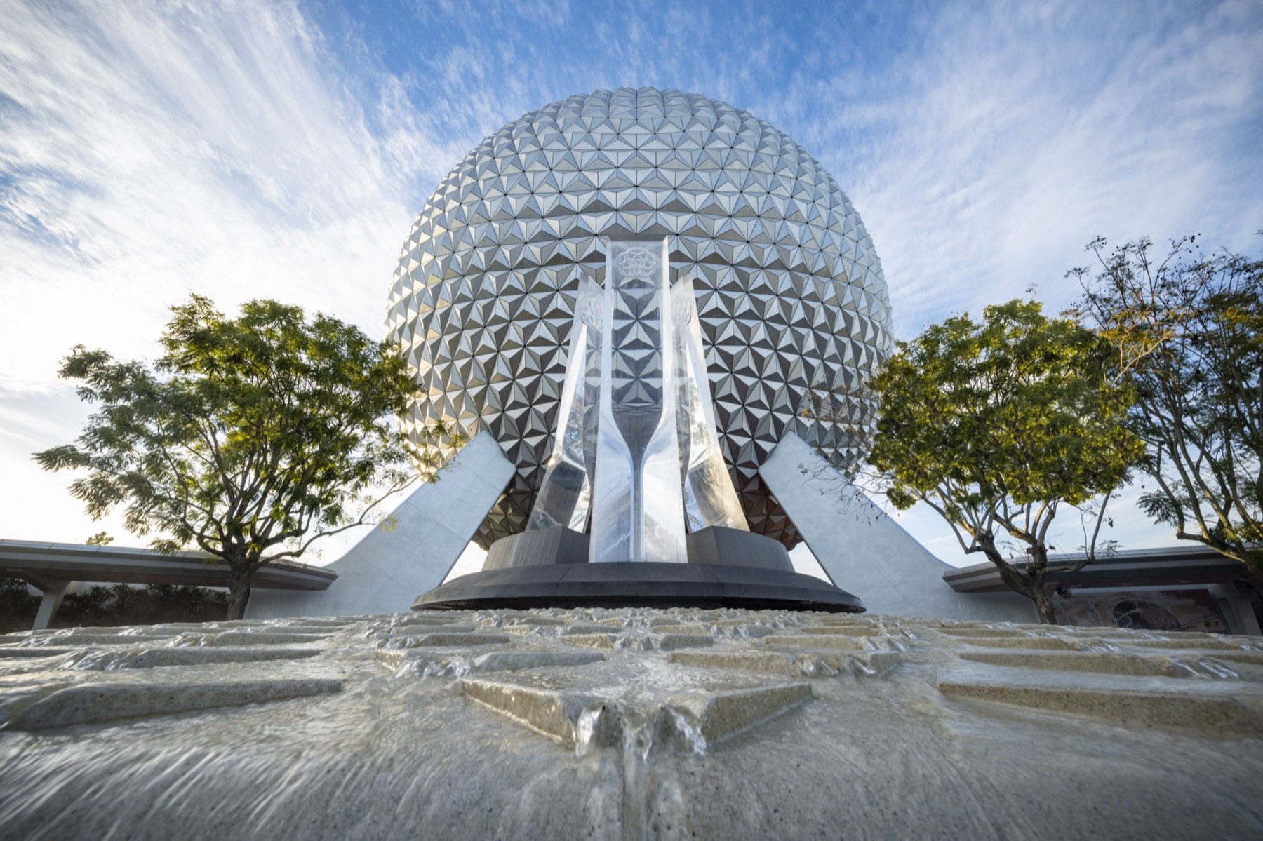 Spaceship Earth behind its fountain under a streaked sky