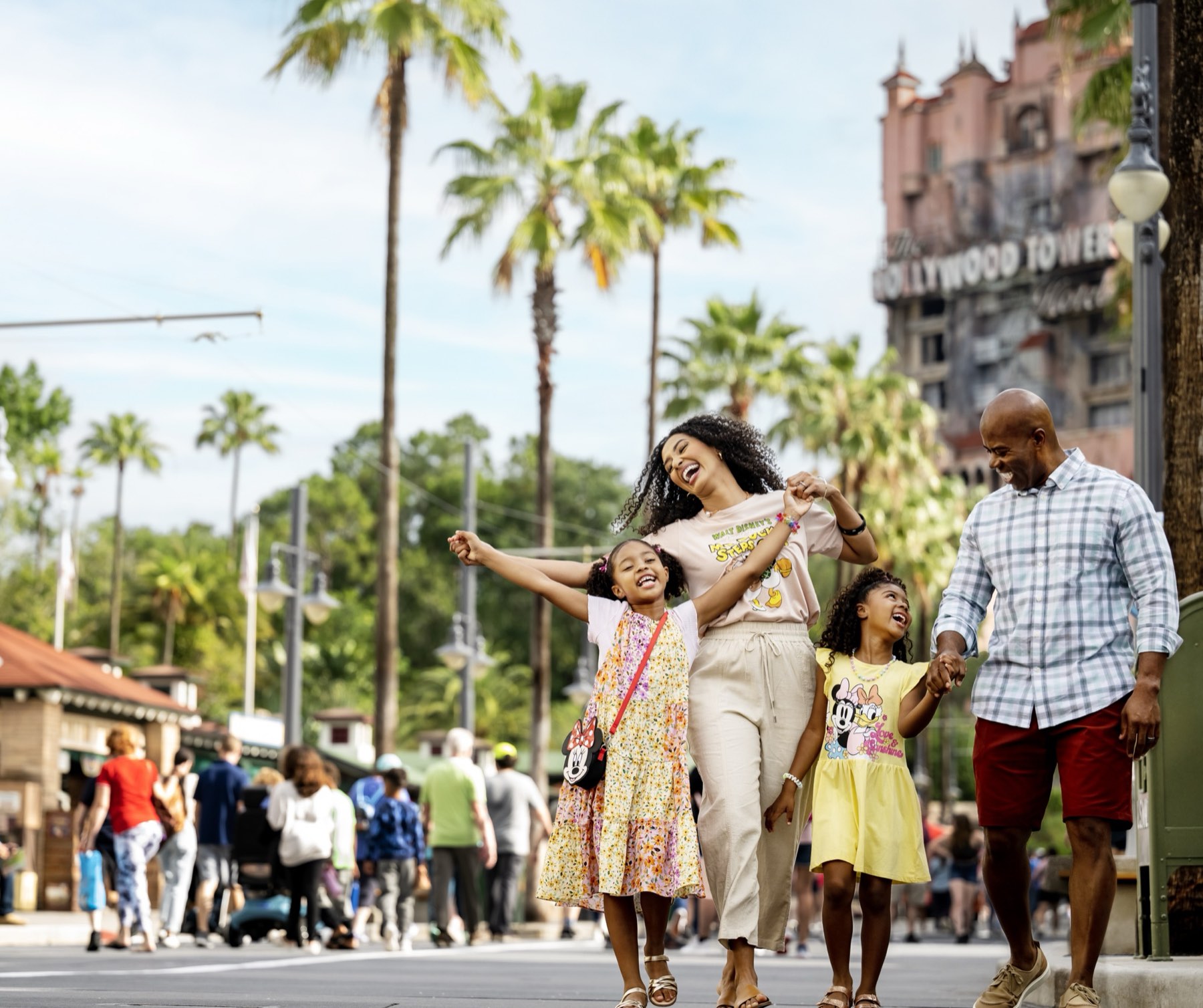 A family walking down Sunset Boulevard with The Twilight Zone Tower of Terror behind them